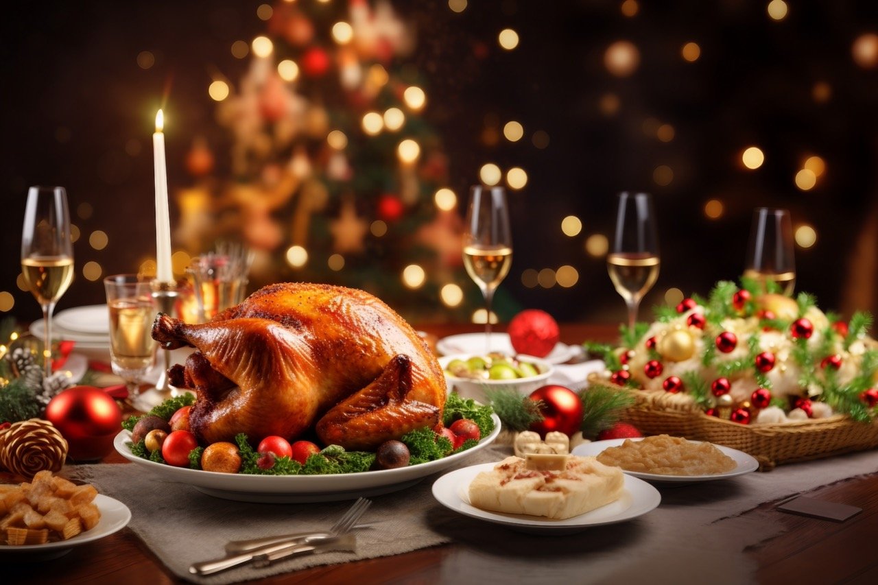 Captured in a stock photo a Christmas dinner table setting beside a decorated Christmas tree