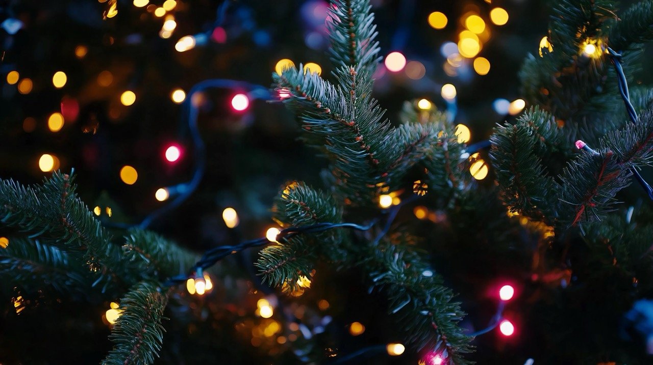 Christmas tree adorned with glowing lights and garlands, celebrating the New Year in a festive, close-up shot