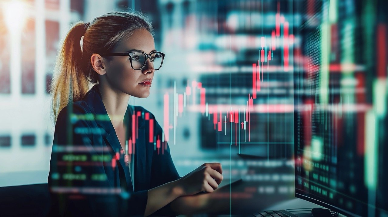 Businesswoman Analyzing Technical Price Graphs and Stock Trading Charts on Computer in Modern Office