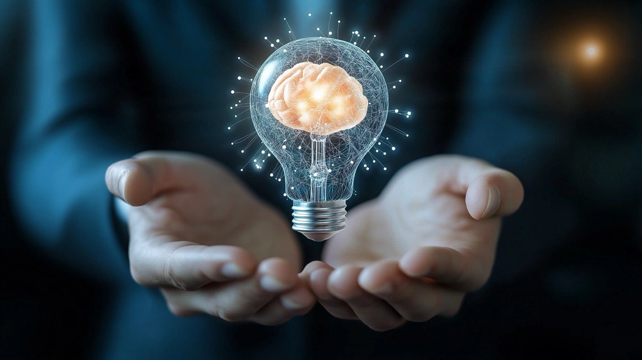 Light Bulb with Brain Inside, Held by Businessman to Represent Innovation, Inspiration, and Intelligence