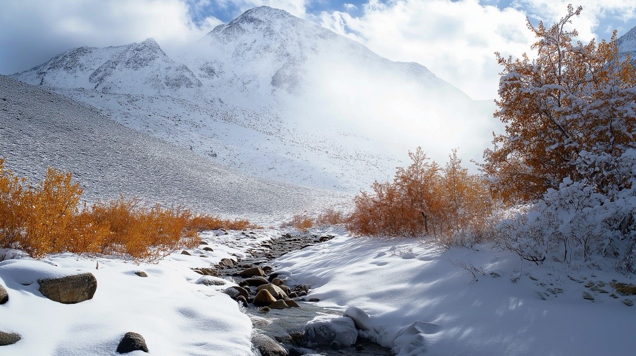 Scenic mountain road in Leh, Ladakh, India, leading to Nubra Valley, surrounded by snow and cliffs.