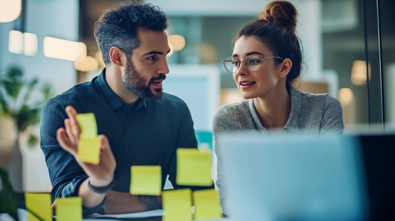 Two Colleagues Discussing Business Ideas, Change, and Strategy in a Corporate Office